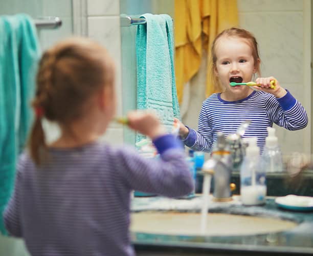 Child Brushing Teeth In Bathroom Mirror Daily Oral Hygiene