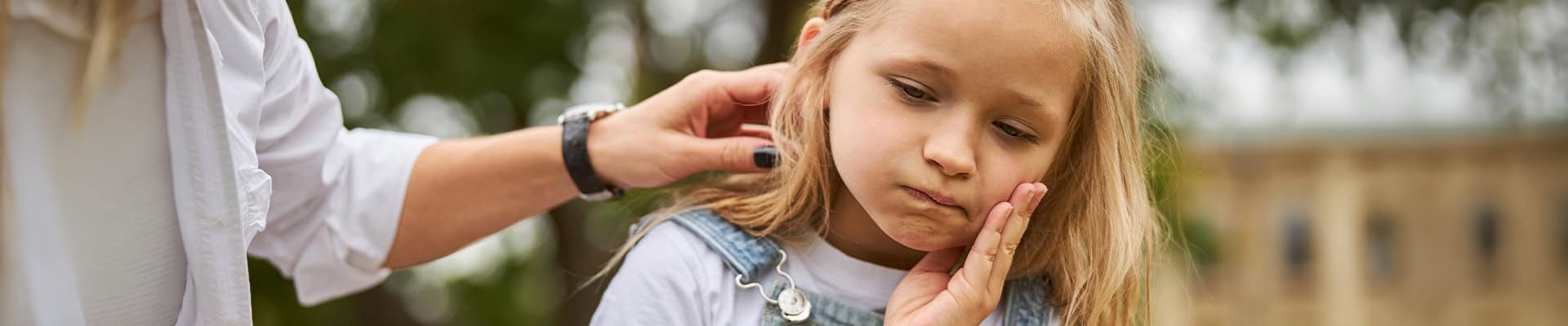 Child Holding Cheek With Toothache Outdoors