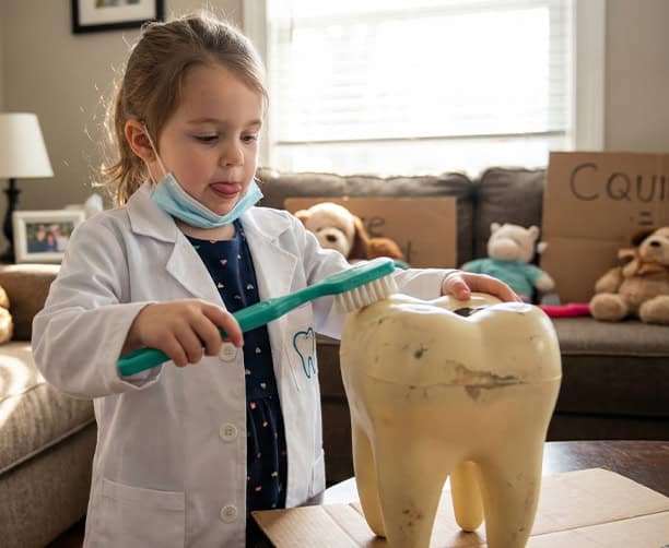 Child Learning To Brush Teeth With Large Tooth Model