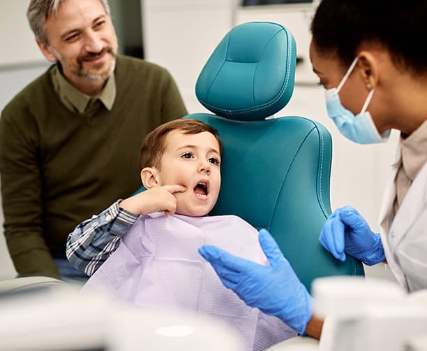 Child Pointing To Tooth During Pediatric Dentist Visit