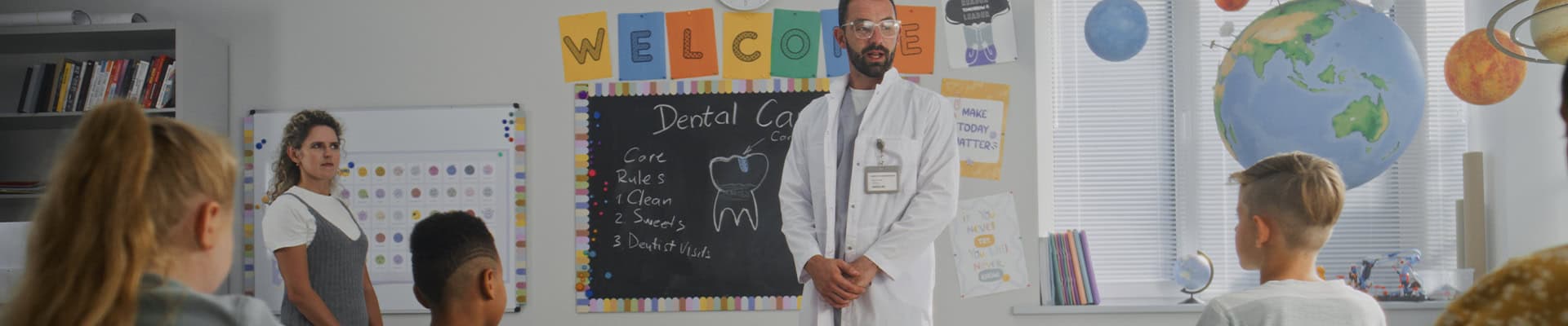 Dentist Teaching Children Dental Care In School Classroom