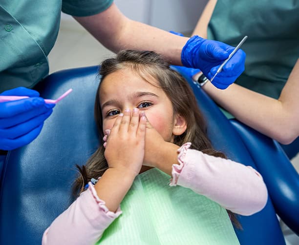 Nervous Child Covering Mouth At Pediatric Dentist Visit