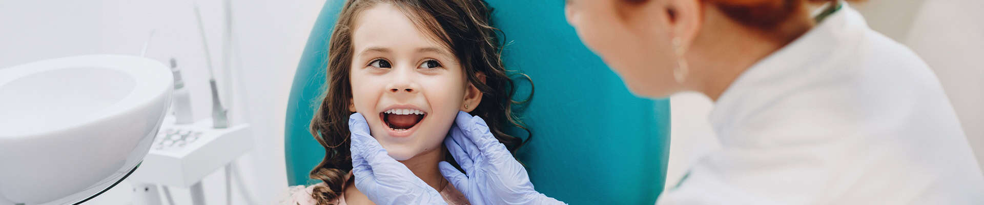 Pediatric Dentist Checking Child Teeth During Exam