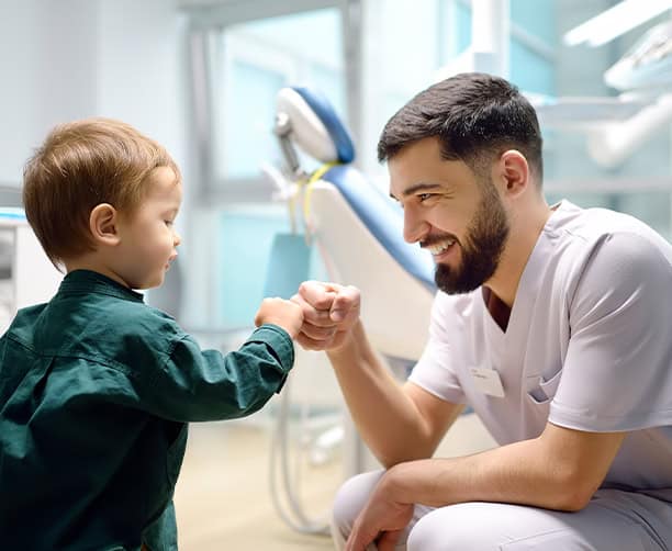 Pediatric Dentist Giving Child Fist Bump After Visit