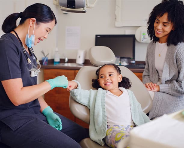 Pediatric Dentist Giving Fist Bump To Child After Dental Checkup