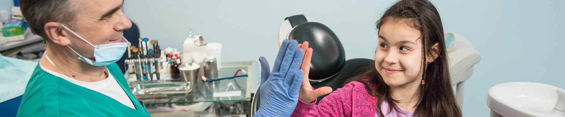 Pediatric Dentist Giving High Five To Child After Checkup