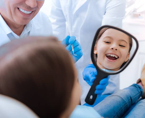 Pediatric Dentist Showing Child Smile With Hand Mirror