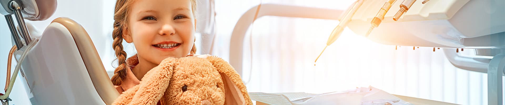 Smiling Child At Pediatric Dentist With Teddy Bear